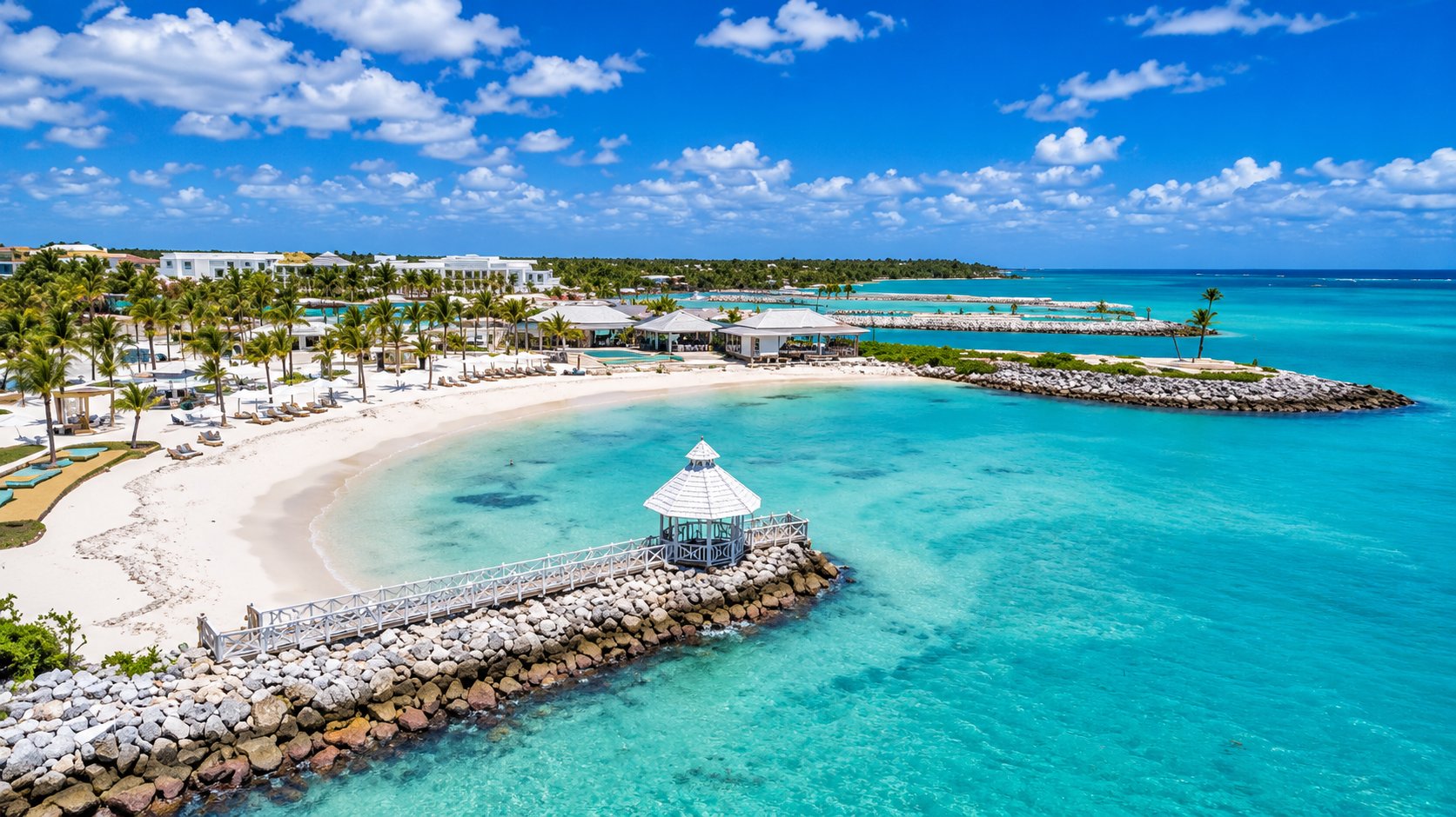 Aerial view of API Beach Club with white-sand beach, pier gazebo and turquoise water at Cap Cana