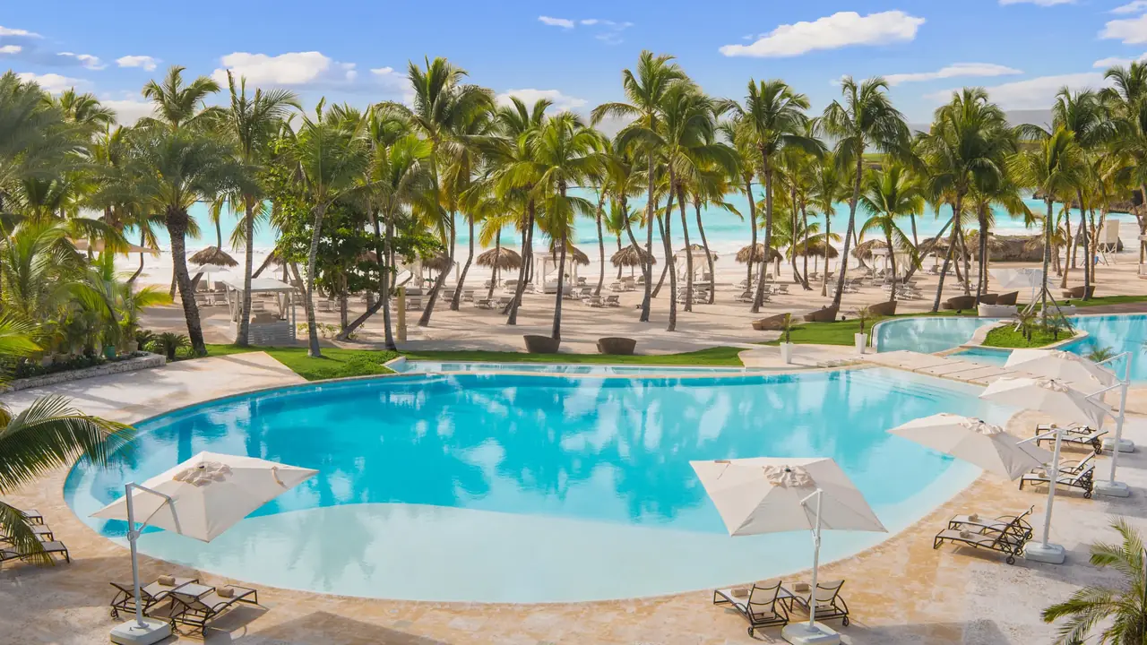 Pool, palm trees and beach at the Eden Roc Beach Club, Cap Cana, Dominican Republic