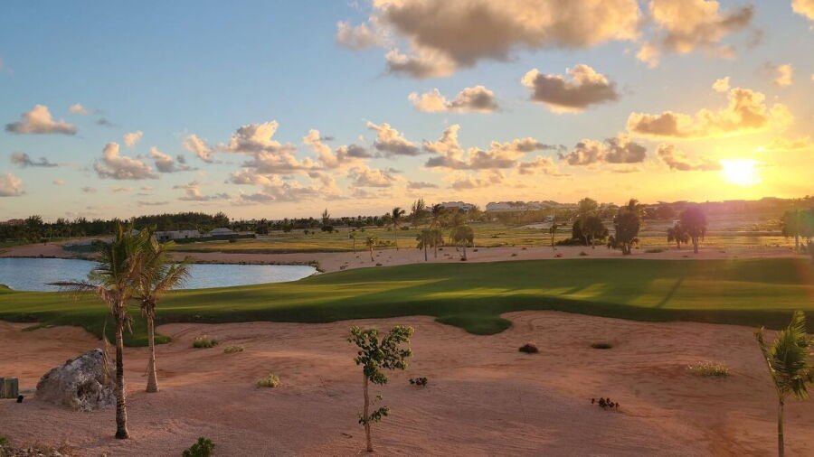 Sunset over a fairway, bunkers and lake at Las Iguanas Golf Course in Cap Cana, Dominican Republic