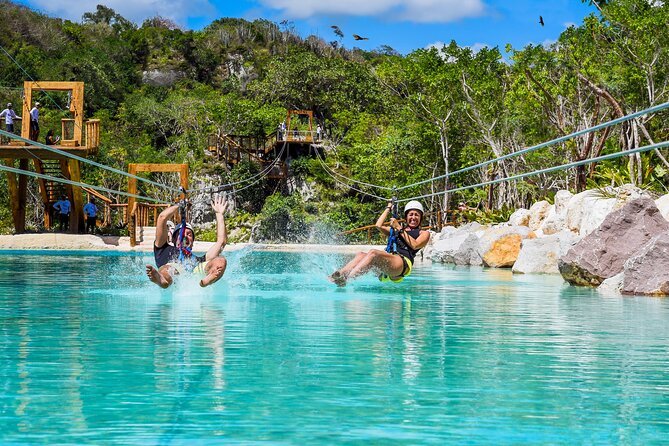 Zip line riders splashing into the turquoise lagoon at Scape Park, Cap Cana, Dominican Republic