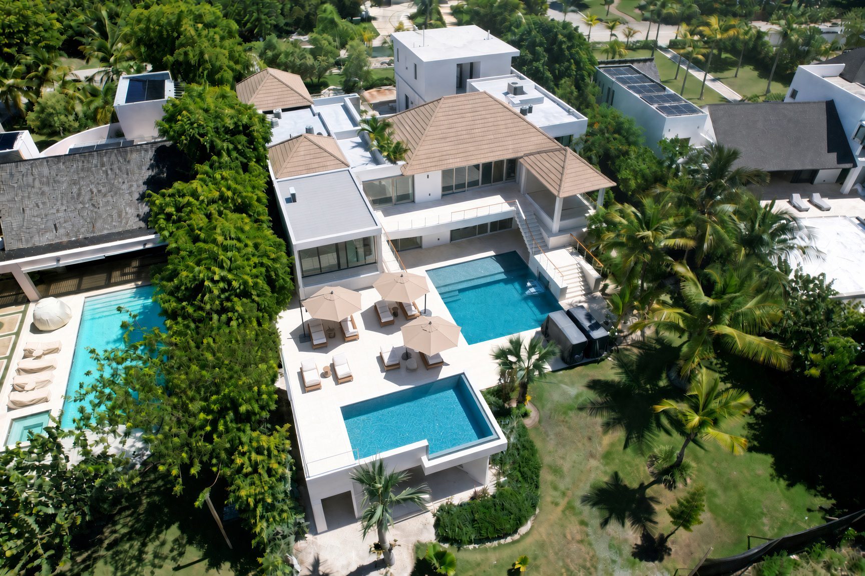 Aerial view of Villa Espada's rooftop infinity pool, ground-level pool and terraces, Cap Cana Dominican Republic